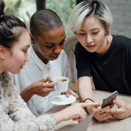 A group of people looking at a social media page on someone's phone.